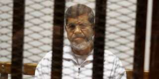 FILE - In this May 8, 2014 file photo, Egypt's ousted Islamist President Mohammed Morsi sits in a defendant cage in the Police Academy courthouse in Cairo, Egypt. An Egyptian court sentenced ousted President Mohammed Morsi to death, Saturday, May 16, 2015,  over  a 2011 mass prison break.. (AP Photo/Tarek el-Gabbas, File)