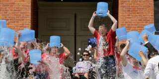Massachusetts Gov. Charlie Baker, right center, and Lt. Gov. Karyn Polito, third from left, participate in the Ice Bucket Challenge with its inspiration Pete Frates, seated in center, to raise money for ALS research, Monday, Aug. 10, 2015, at the Statehouse in Boston. (AP Photo/Charles Krupa)
