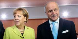 German Chancellor Angela Merkel, left, welcomes French Foreign Minister Laurent Fabius, right, for the German government's cabinet meeting at the chancellery in Berlin, Wednesday, Oct. 15, 2014. Laurent Fabius attends the cabinet meeting as a guest. (AP Photo/Markus Schreiber)