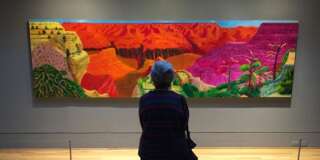 This Feb. 20, 2016 photo shows a visitor gazing at David Hockney's depiction of the Grand Canyon in a show called