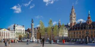 Grand Place with the Belfry tower of the Chamber of Commerce and the statue of  the Column of the Goddess (memorial of the siege of 1792).