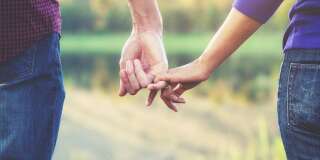 Un homme et une femme en couple se tiennent la main.
