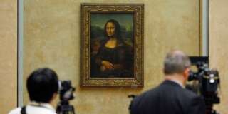 Members of the media are gathered next to the Mona Lisa, during an event to unveil the new lighting of Leonardo da Vinci's painting Mona Lisa, also known as La Joconde, at the Louvre museum in Paris, Tuesday June 4, 2013. Mona Lisa is now illuminated by LED lighting. The lighting had to meet various technical specifications, but also meet the more subjective and aesthetic requirements of the museum Director and Franceâs Historical Monuments Committee.(AP Photo/Remy de la Mauviniere)