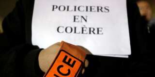 Un policier porte un écriteau lors d'une manifestation le 1er novembre à Paris.  REUTERS/Christian Hartmann