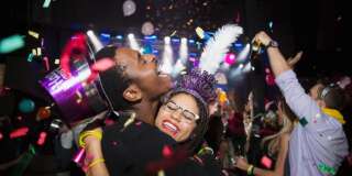 Confetti falling hugging couple enjoying New Year celebration