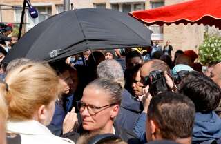 Emmanuel Macron, protégé par un parapluie, le 27 avril 2022 au marché Saint-Christophe de Cergy.
