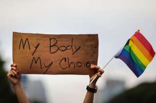 Un activiste LGBT+ porte une pancarte 