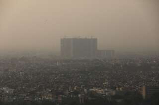 Sur cette photo prise le 26 ocotbre 2020, les bâtiments de New Delhi sont à peine visible dans le brouillard de pollution et de poussière.