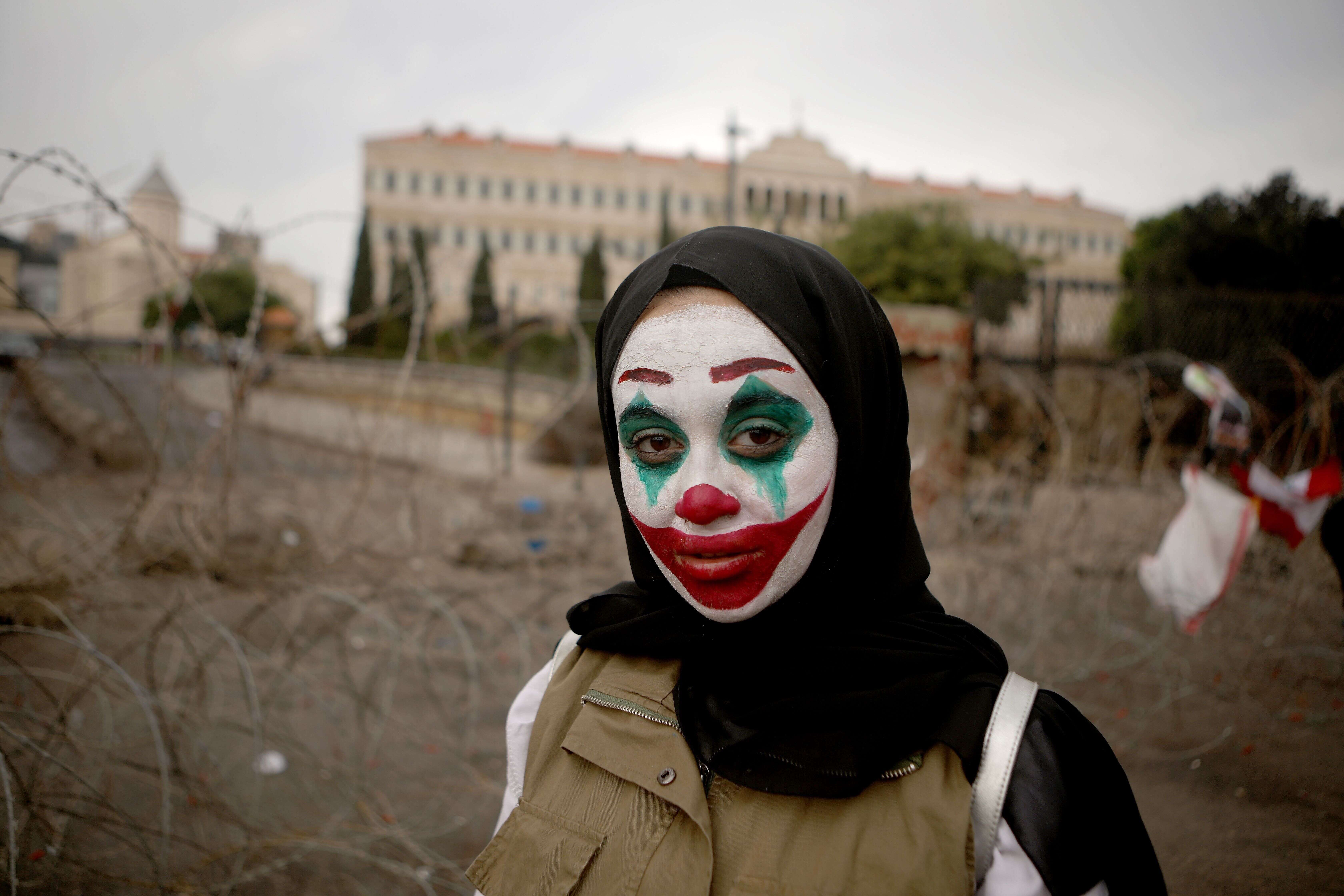 Une libanaise manifeste en arborant le maquillage du Joker, afin de réclamer de meilleures conditions de vie et le renvoi d'une classe politique corrompue, à Beyrouth, le 23 octobre 2019.