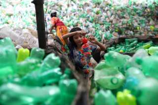 En marge de la signature d'un partenariat avec Suez, Loop Industries a déclaré être capable de produire 4,2 milliards de bouteilles de soda en plastique recyclé. Une jeune fille s'amuse avec un jouet en plastique trouvé dans une usine de recyclage à Dhaka, au Bangladesh, le 8 juillet 2019. Image d'illustration.
