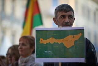 Un Kurde tient une carte du Kurdistan syrien, appelé 