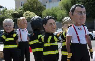 Des manifestants anti-G7 portent des masques à l'effigie des dirigeants attendus à Biarritz pour le sommet 2019