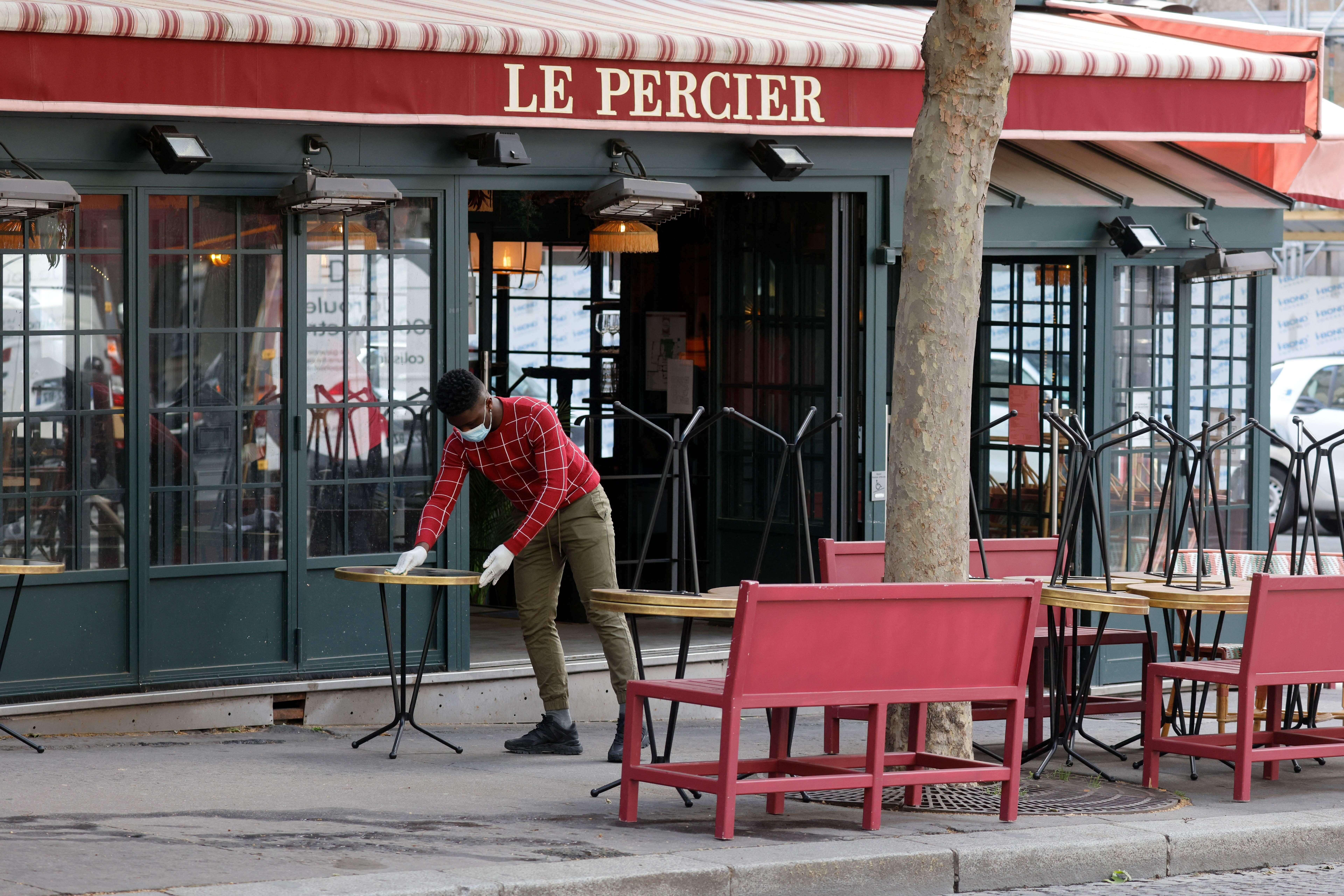Les terrasses des bars et restaurants limitées à la moitié de leur capacité à partir du 19 mai (Photo d'illustration: un café parisien se prépare à la réouverture du 19 mai en terrasse. Photo by LUDOVIC MARIN/AFP)