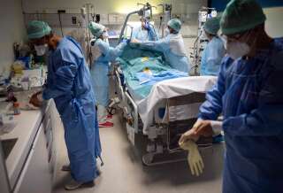 Du personnel hospitalier s'affaire dans la chambre d'un patient Covid à la clinique Muret près de Toulouse (Photo by LIONEL BONAVENTURE/AFP via Getty Images)