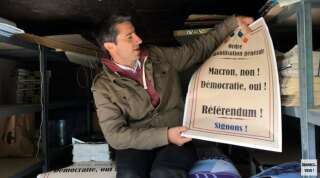 François Ruffin présente l'une des deux affiches qu'il a fait faire pour mener campagne contre la privatisation d'ADP.