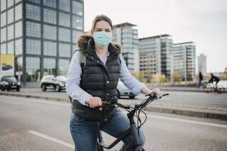 Illustration: une jeune femme à vélo portant un masque dans les rues de Berlin. (Photo Nils Hasenau via Getty Images)