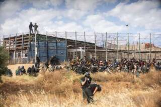 Des migrants arrivent sur le sol espagnol après avoir traversé les clôtures séparant l'enclave espagnole de Melilla du Maroc à Melilla, en Espagne, le vendredi 24 juin 2022.