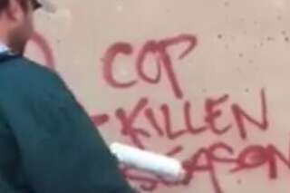 Il recouvre un graffiti anti-police avec un poster de bonhomme de neige