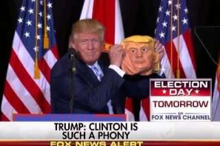 Donald Trump s'amuse avec un masque de Donald Trump lors d'un meeting