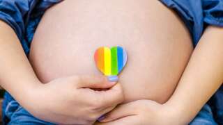 Pregnant woman shows on camera heart LGBT Pride Rights Lesbian Gay Bisexual Transgender Geek on city sunny day background. Pride mounth day