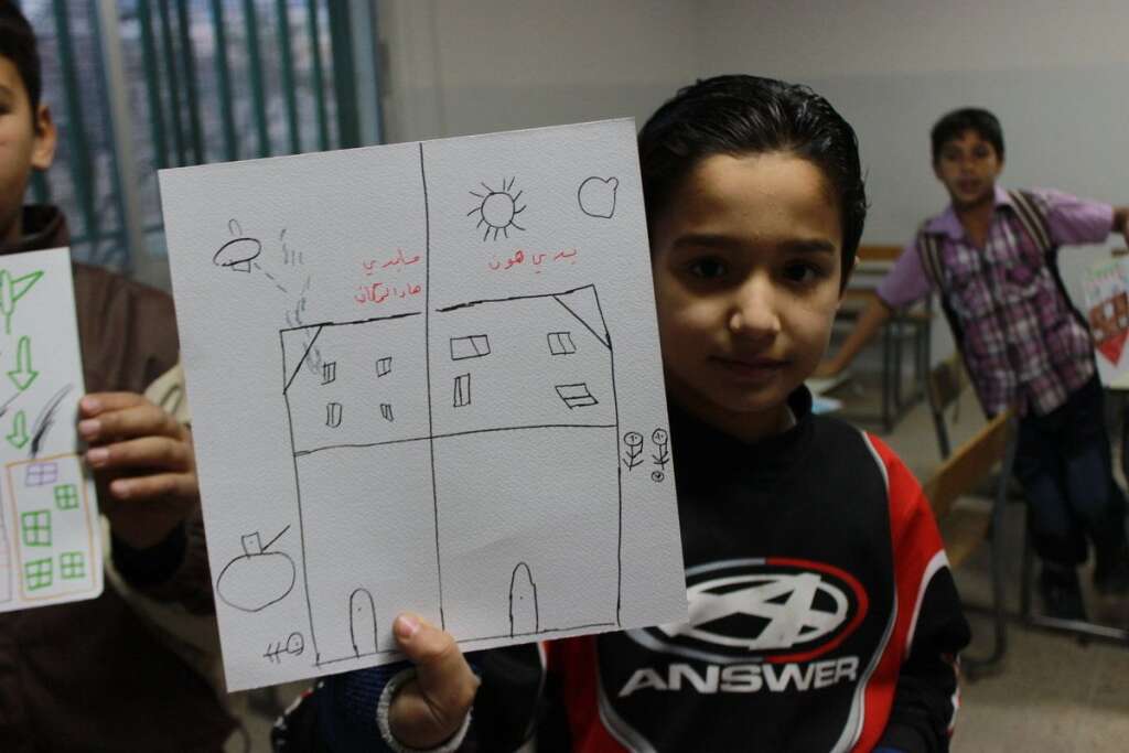 Ahmad, 11 ans - Ahmad a dessiné sa maison avant et après la guerre. Côté guerre, il a inscrit: "Je n'aime pas cet endroit". De l'autre : "C'est là que je veux être".