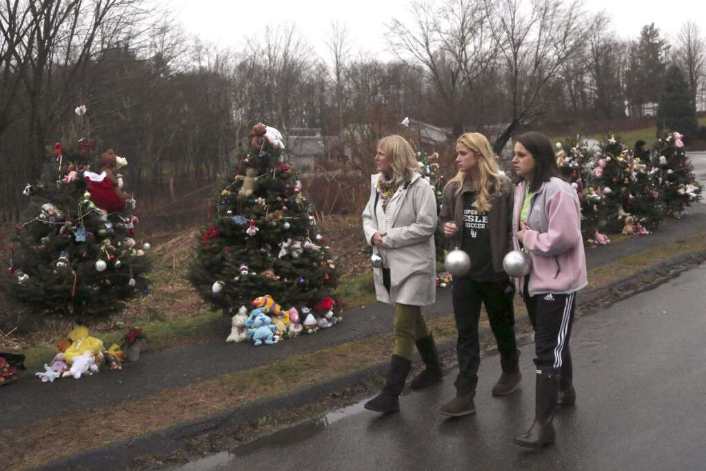 - Mourners carry ornaments to decorate the Christmas trees at one of the makeshift memorials for the Sandy Hook Elementary School shooting victims, Monday,Dec. 17, 2012 in Newtown, Conn. Authorities say gunman Adam Lanza killed his mother at their home on Friday and then opened fire inside the Sandy Hook Elementary School in Newtown, killing 26 people, including 20 children, before taking his own life. (AP Photo/Mary Altaffer)