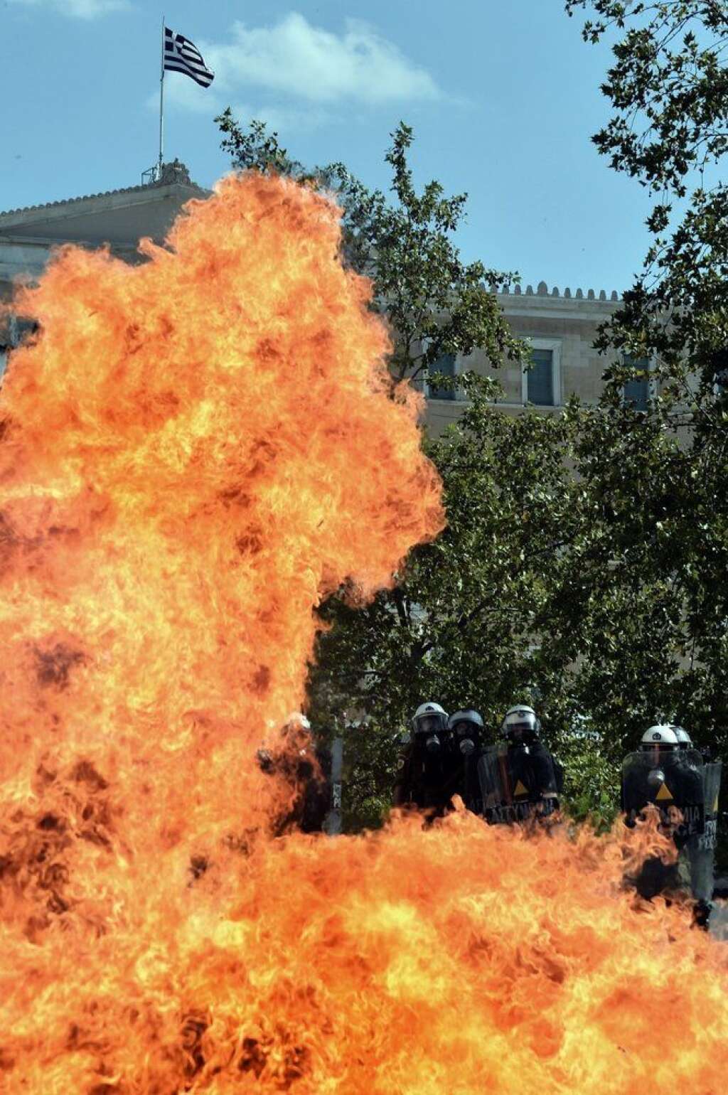 GREECE-FINANCE-PUBLIC-DEBT-EU-STRIKE - A firebomb explodes in front of riot police forces during clashes with demonstrators during a rally marking a 24-hour general strike on October 18, 2012 near the parliament in Athens. Greek riot police on Thursday fired tear gas to disperse protesters at an anti-austerity rally in Athens held during a national general strike as EU leaders were to tackle the eurozone crisis at a summit in Brussels.  AFP PHOTO / ARIS MESSINIS        (Photo credit should read ARIS MESSINIS/AFP/Getty Images)
