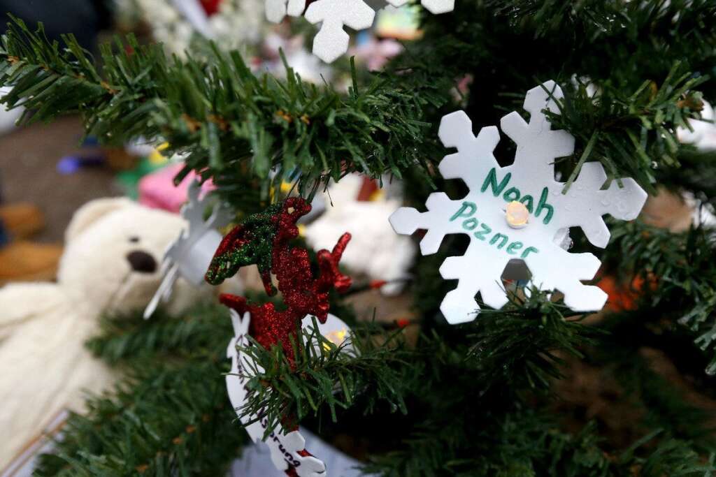 - A snowflake ornament with the name of 6-year-old Noah Pozner hangs on a Christmas tree at a makeshift memorial in the Sandy Hook village of Newtown, Conn., Monday, Dec. 17, 2012, as the town mourns victims killed in Friday's school shooting. Pozner, who was killed Friday when gunman Adam Lanza opened fire inside the Sandy Hook Elementary School, will be buried Monday. (AP Photo/Julio Cortez)
