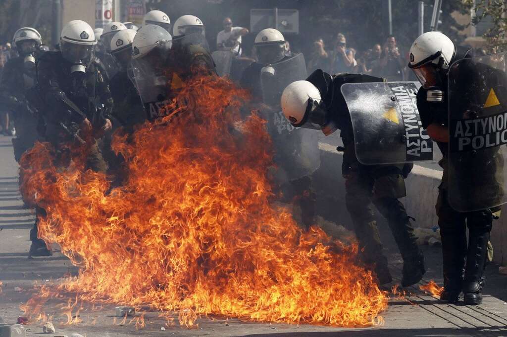 - Protesters throw petrol bombs at riot police officers during a 24-hour nationwide general strike in Athens on Thursday, Oct. 18, 2012. Hundreds of youths pelted riot police with petrol bombs, bottles and chunks of marble Thursday as yet another Greek anti-austerity demonstration descended into violence. (AP Photo/Kostas Tsironis)
