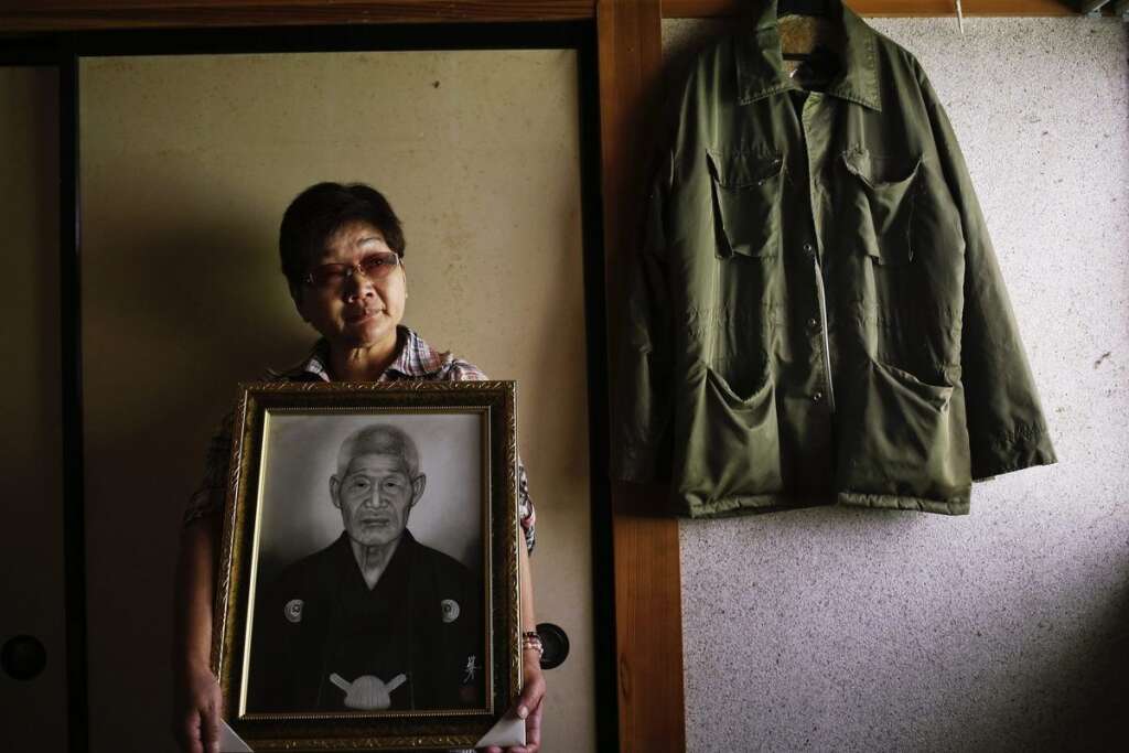 - Une femme tient le portrait de son beau-père, suicidé après la catastrophe.