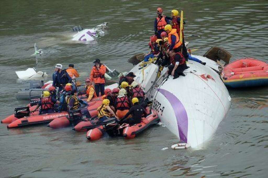 Rescue personnel work to free passengers from a TransAsia ATR 72-600 turboprop plane that crash-landed into a river outside Taiwan's capital Taipei in New Taipei City on February 4, 2015. The passenger plane with 58 people on board was on a domestic flight when it plunged into the river, with at least 10 people rescued and dozens trapped inside, according to television reports.   AFP PHOTO / SAM YEH        (Photo credit should read SAM YEH/AFP/Getty Images)