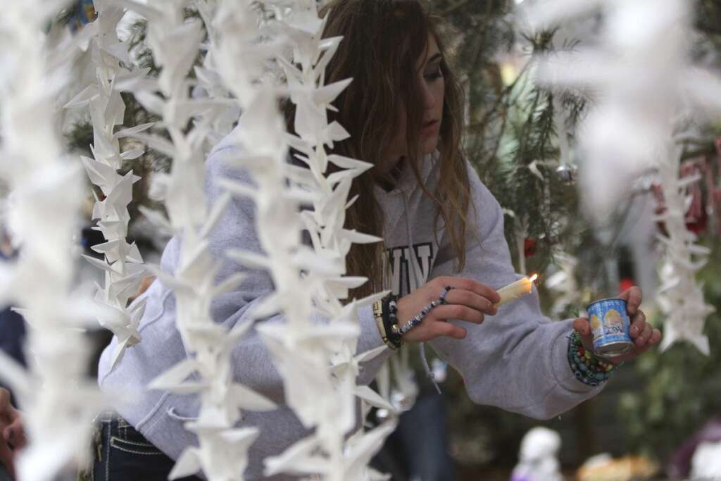 - Jamie Duncan, 16, of Newtown, Conn., lights a candle at one of the makeshift memorials for the Sandy Hook Elementary School shooting victims, Monday,Dec. 17, 2012 in Newtown, Conn. Authorities say gunman Adam Lanza killed his mother at their home on Friday and then opened fire inside the Sandy Hook Elementary School in Newtown, killing 26 people, including 20 children, before taking his own life. (AP Photo/Mary Altaffer)