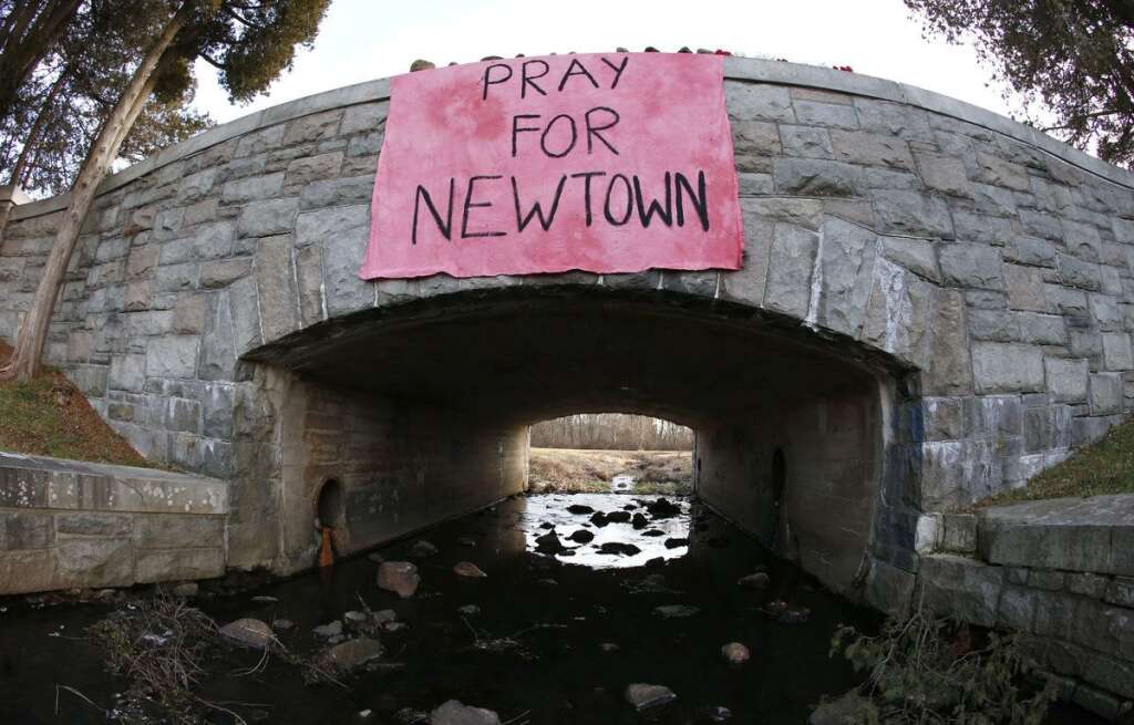 - In this photo taken with a fisheye lens, a message honoring the victims that died a day earlier when a gunman opened fire at an elementary hang from a bridge near Hawley Pond, Saturday, Dec. 15, 2012, in Newtown, Conn. The massacre of 26 children and adults at Sandy Hook Elementary school elicited horror and soul-searching around the world even as it raised more basic questions about why the gunman, 20-year-old Adam Lanza, would have been driven to such a crime and how he chose his victims. (AP Photo/Julio Cortez)