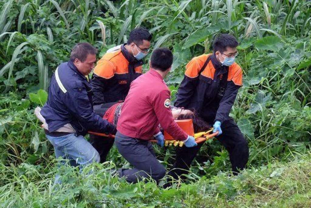 An injured passenger (C) is stretchered by emergency personnel up the river bank after a TransAsia ATR 72-600 turboprop plane crash-landed into the Keelung river outside Taiwan's capital Taipei in New Taipei City on February 4, 2015. The low-flying passenger plane, TransAsia Flight GE235 with 58 people on board, clipped a road bridge and plunged into the river outside Taiwan's capital with at least 11 feared dead and many trapped inside.   AFP PHOTO / SAM YEH        (Photo credit should read SAM YEH/AFP/Getty Images)