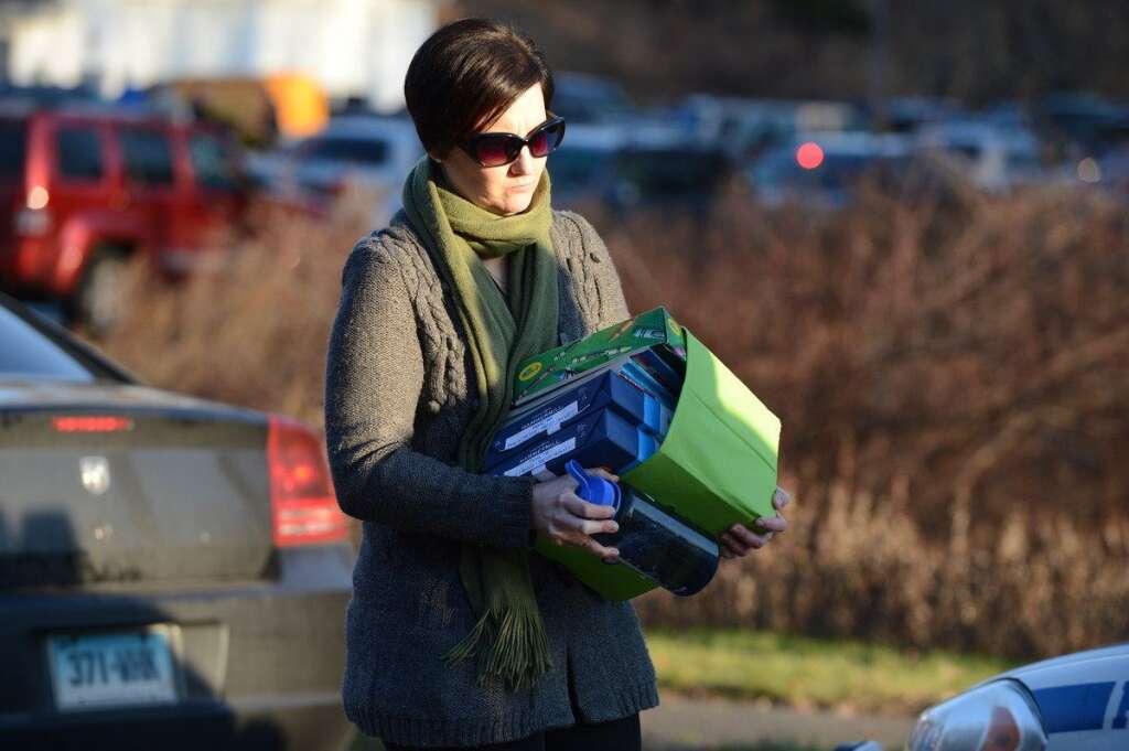 Sandy Hook Elementary School Shooting - An unidentified woman on December 14, 2012 leaves the scene at the aftermath of  a school shooting at a Connecticut elementary school  that brought police swarming into the leafy neighborhood, while other area schools were put under lock-down, police and local media said. Local media quoted  that the gunman had died at the Sandy Hook Elementary School in Newtown, Connecticut, northeast of New York City.  At least 27 people, including 20 children, were killed on Friday when at least one shooter opened fire at an elementary school in Newtown, Connecticut, CBS News reported, citing unnamed officials. AFP PHOTO/DON EMMERT