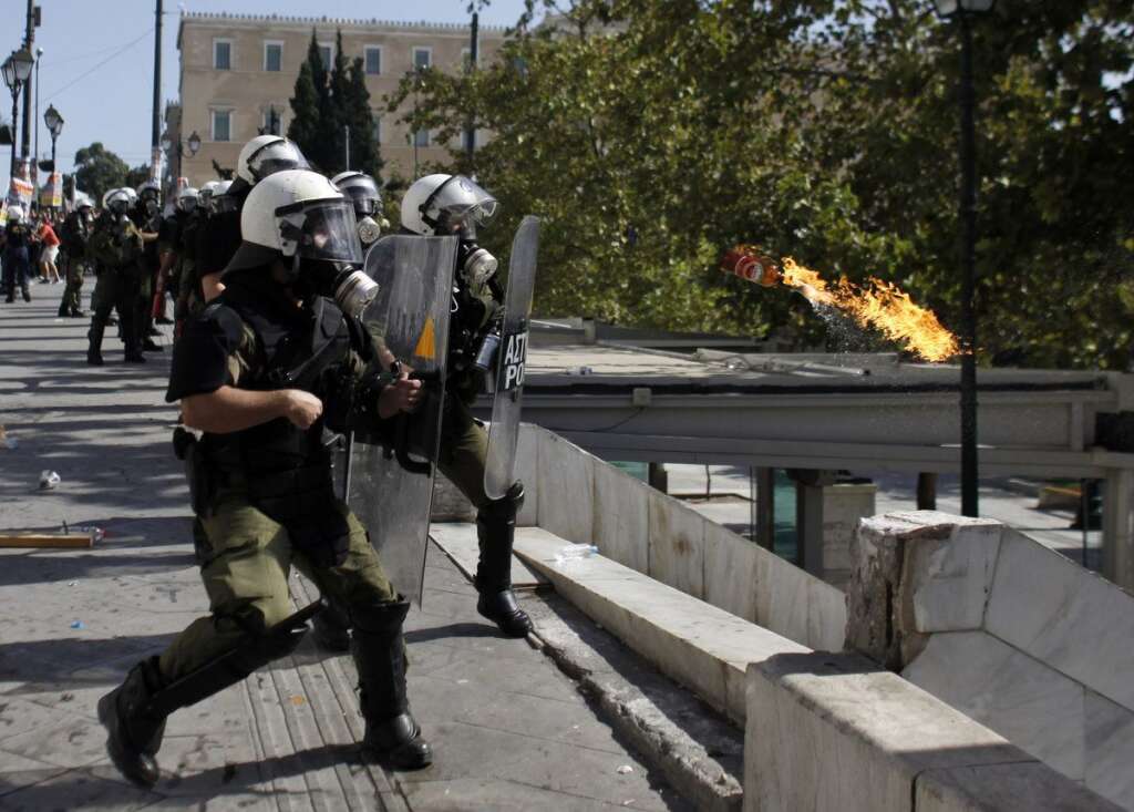 - Protesters throw a petrol bomb at riot police during clashes during the 24-hour nationwide general strike in Athens on Thursday, Oct. 18, 2012. Hundreds of youths pelted riot police with petrol bombs, bottles and chunks of marble Thursday as yet another Greek anti-austerity demonstration descended into violence. (AP Photo/Kostas Tsironis)