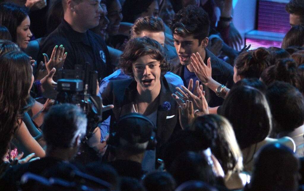 Harry Styles, Zayn Malik - Harry Styles, center, and Zayn Malik, background right, of musical group One Direction, walk onstage to accept the award for best new artist at the MTV Video Music Awards on Thursday, Sept. 6, 2012, in Los Angeles. (Photo by Matt Sayles/Invision/AP)