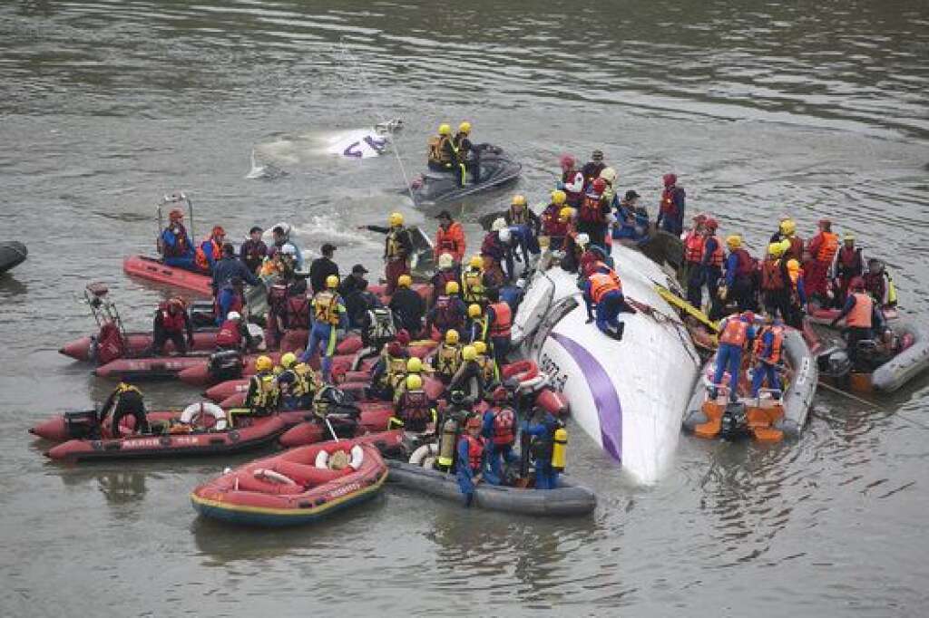 TAIPEI, TAIWAN - FEBRUARY 04:  Rescue teams work to free people from a TransAsia Airways ATR 72-600 turboprop airplane that crashed into the Keelung River shortly after takeoff from Taipei Songshan airport on February 4, 2015 in Taipei, Taiwan. Over 50 people were onboard the aircraft when it clipped a bridge and crashed into the river. Twelve deaths have currently been reported. (Photo by Ashley Pon/Getty Images)