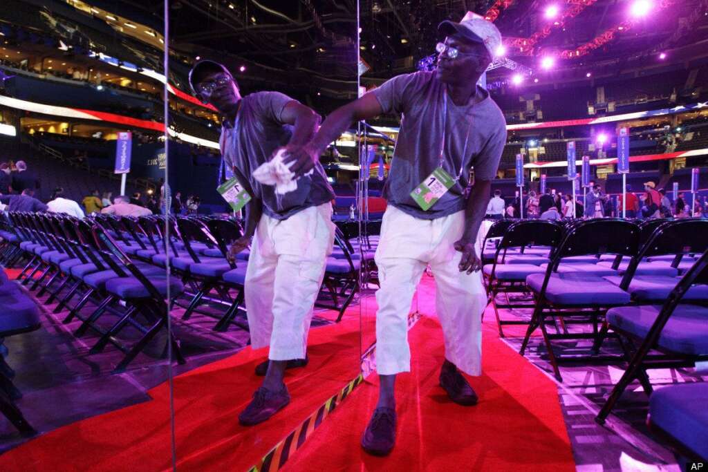 Scott Kiss - Worker Patrick Gayle of Kissimmee, Fla. wipes the mirror-sided camera stands on the floor of the Republican National Convention in the Tampa Bay Times Forum in Tampa, Fla., on Sunday, Aug. 26, 2012. (AP Photo/Charlie Neibergall)