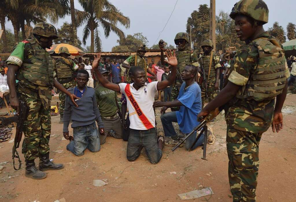 VUE PAR L'AFP - Mais les opérations de désarmement et d'extraction des milices sont parfois un peu plus spartiates, comme l'atteste cette image datée du 15 janvier 2014. Ici, des soldats Burundi épaulés par l'armée française fouillent des milices anti-Balaka sur lesquelles des grenades ont été retrouvées.