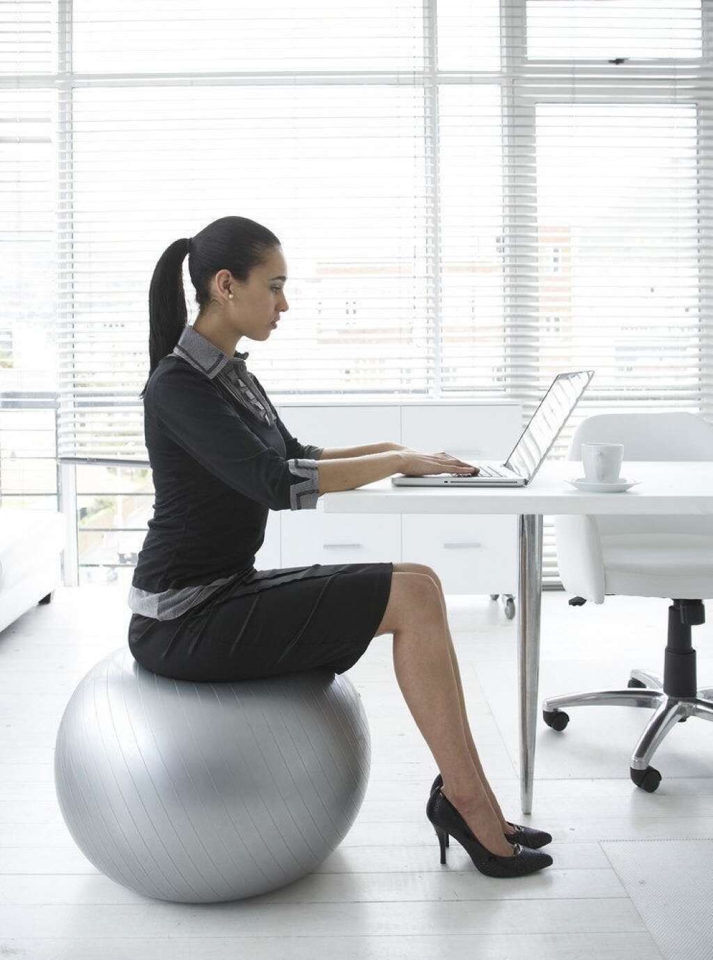La chaise "boule de yoga" - Il est essentiel au bureau d'être bien assis. Nul besoin d'acheter une nouvelle chaise. Prenez avec vous votre ballon de yoga et asseyez vous dessus face à votre bureau. Vous aurez le dos droit, les bras tendus à bonne distance du clavier et la tête non inclinée.