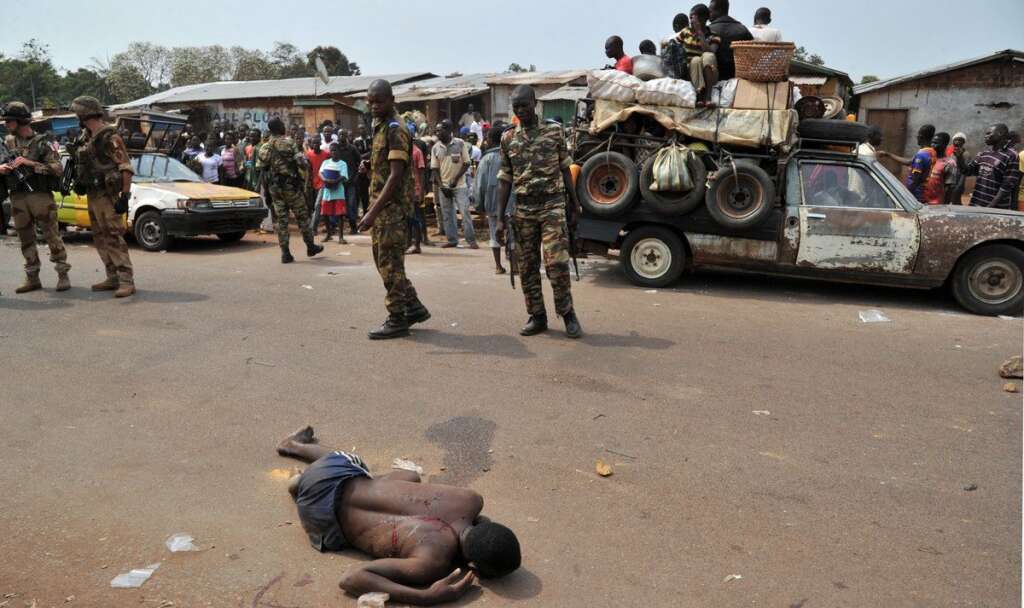 VUE PAR L'AFP - Sur cette photo datée du 24 janvier dernier, des soldats français et africains gardent le cadavre d'un musulman, battu à mort.
