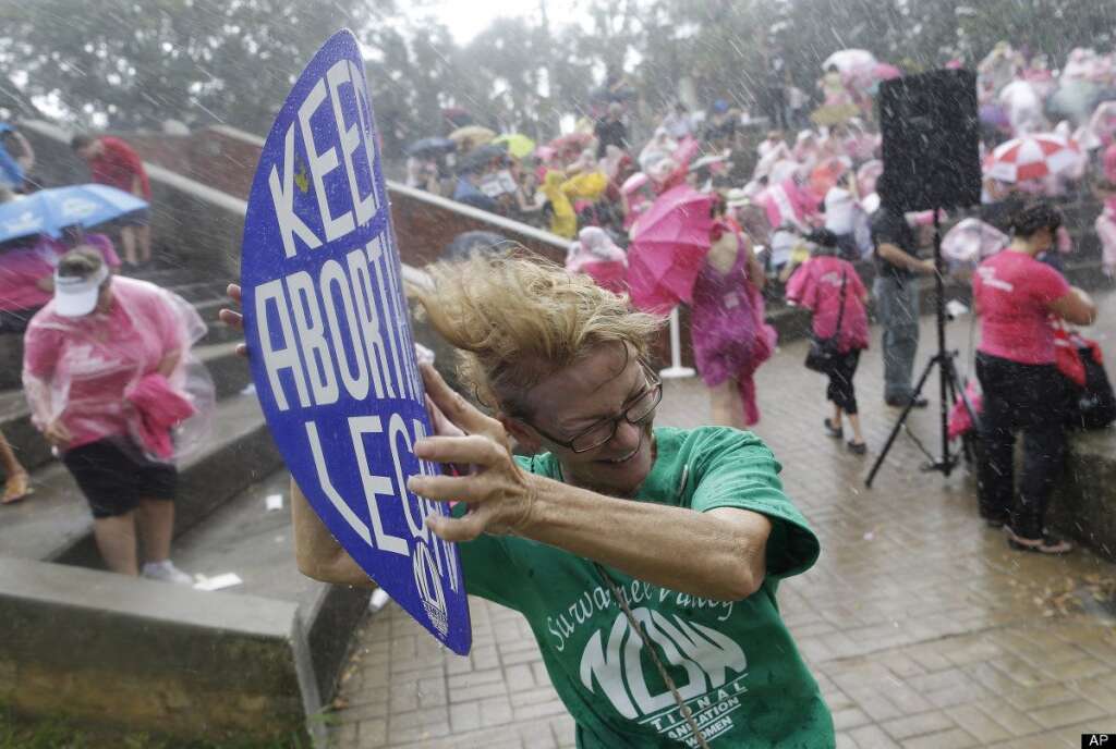 Catherine Akin, of Jasper, Fla., a demonstrators participate in a protest rally in the rain, Wednesday, Aug. 29, 2012, in Tampa, Fla. Protestors gathered in Tampa to march in demonstration against the Republican National Convention. (AP Photo/Patrick Semansky)