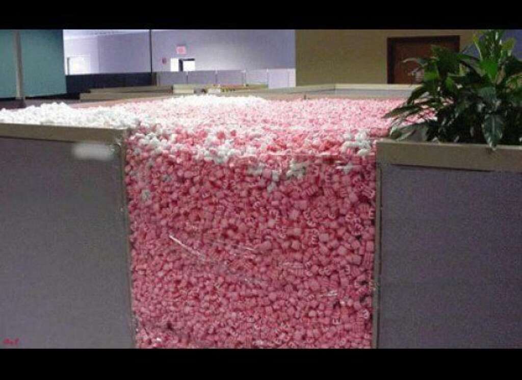 Packing Peanuts Galore - It looks like this employee is being shipped overseas. (Via <a href="http://theprodesigner.com/23-funny-cubicle-pranks/" target="_hplink">The Pro Designer</a>)