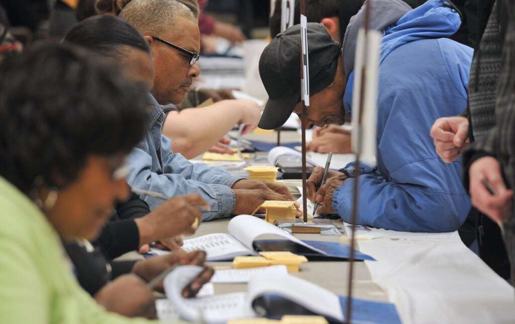 US-VOTE-2012-ELECTION - Election officials verify addresses of voters at the polling station at Metropolitan AME Church  in Washington, DC on November 6, 2012. Americans headed to the polls Tuesday after a burst of last-minute campaigning by President Barack Obama and Mitt Romney in a nail-biting contest unlikely to heal a deeply polarized nation. AFP PHOTO/Mladen ANTONOV        (Photo credit should read MLADEN ANTONOV/AFP/Getty Images)