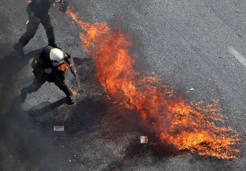 - Riot police try to avoid a petrol bomb in Athens, during a 24-hour nationwide general strike on Thursday, Oct. 18, 2012. Greece was facing its second general strike in a month Thursday as workers protested over another batch of austerity measures that are designed to prevent the bankruptcy of the country. (AP Photo/Thanassis Stavrakis)