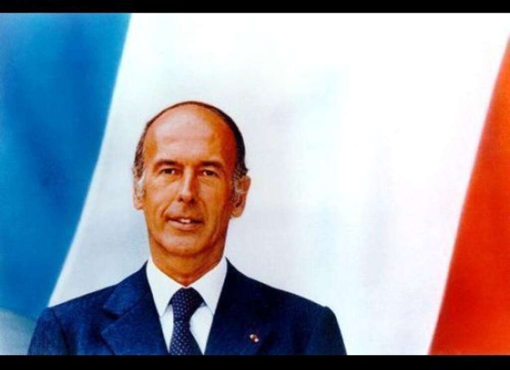 Valéry Giscard d'Estaing - Fini le plan américain et la bibliothèque. VGE apparaît souriant sur fond de drapeau tricolore. C'est d'ailleurs la première fois que le drapeau apparaît dans un portrait officiel.    On remarquera également que l'habit de cérémonie est resté au placard.