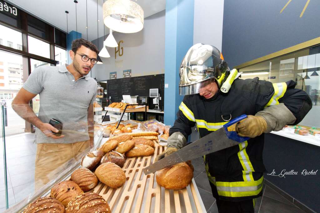 Calendrier Pompiers Rennes 2019 - En mars, le pompier-boulanger a le coup de scie pour couper son pain.