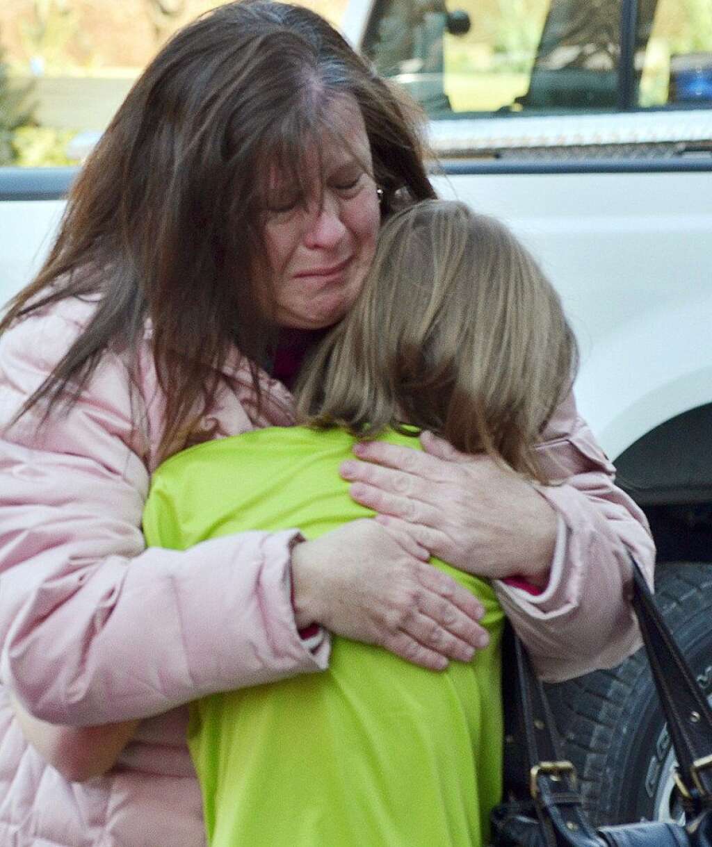 Sandy Hook Elementary School Shooting - A mother hugs her daughter following a shooting at the Sandy Hook Elementary School in Newtown, Conn., about 60 miles (96 kilometers) northeast of New York City, Friday, Dec. 14, 2012. A gunman entered the school Friday morning and killed at least 26 people, including 20 young children. (AP Photo/The New Haven Register, Melanie Stengel)
