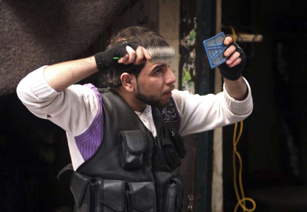 - Un membre de l'Armée syrienne libre brosse ses cheveux, dans la vieille ville d'Alep, le 25 décembre 2012.